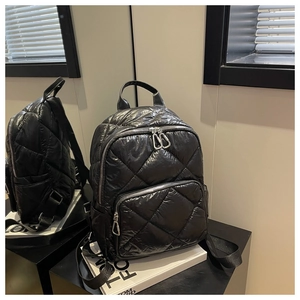 Details des schwarzen gesteppten Rucksacks mit Reißverschlüssen und Rautenmuster-Textur