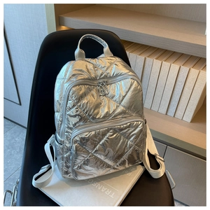 Details des silbernen Stepprucksacks mit gesteppter Textur und Reißverschlüssen