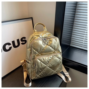 Detail eines gesteppten Metallic-Rucksacks mit Reißverschlüssen und Rautenmuster