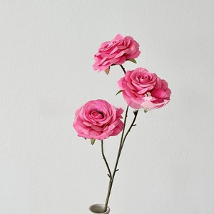 Detailed view of artificial pink roses with three heads and realistic green stems