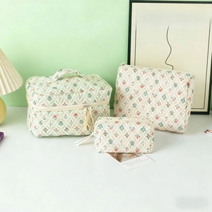 Close-up of three-piece floral quilted cotton makeup bag set in varying sizes