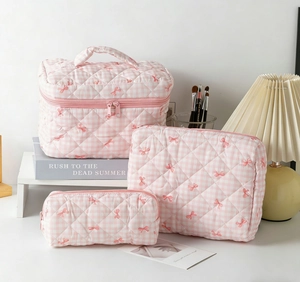 Detailed set of three pink checkered quilted toiletry bags with floral bow patterns