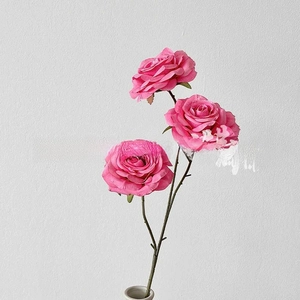 Detailed view of artificial pink rose with three heads in a white ceramic vase
