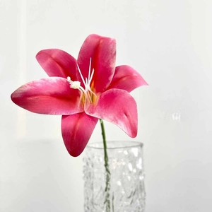 Macro detail of rose lily faux flower in a cracked texture glass vase for home decor