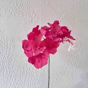 Detail of vibrant rose red artificial flower branch with silk petals for wedding decor