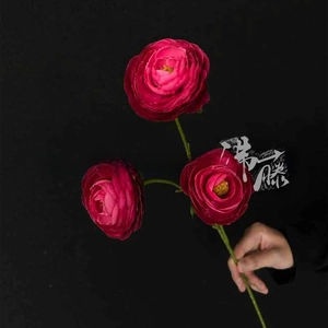 Close-up of artificial magenta ranunculus flowers with three heads for wedding decor