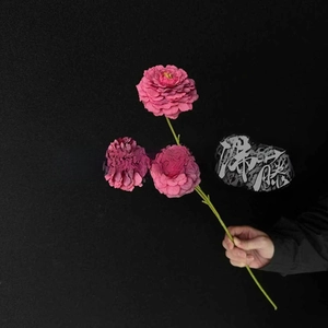 Close-up of vibrant pink artificial dahlia with three blooming heads and green stem