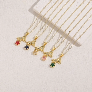 Elegant gold bear and star zircon necklaces set in five colors on minimalist stone display