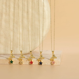 Detail of five colorful teddy bear and star zircon pendants on fine gold chain necklaces