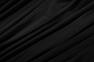 Vue macro d'un tissu en maille noire plissée avec texture respirante et bords précis