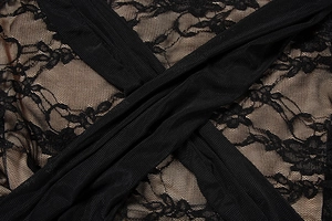 Gros plan sur robe en dentelle noire avec motifs floraux et détails de bretelles