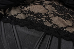 Détails de broderie en dentelle florale et tissu plissé sur une robe noire élégante