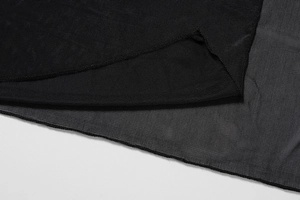 Gros plan sur le tissu en maille noire montrant la texture fine et l'ourlet cousu