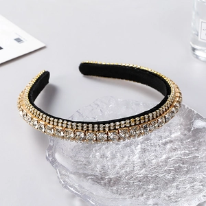 Detail showing luxury layered rhinestone headband with gold finish on glass tray