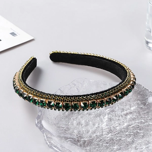 Macro view of luxurious green crystal headband with gold chain and black velvet