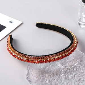 Detail of red crystal headband with gold metal base and luxury rhinestone layering