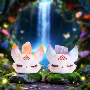 Detailed view of two cute white fox figurines with orange and purple crystal stones