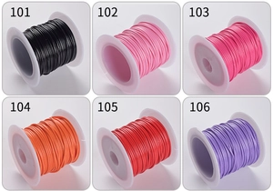 Macro view of six color variations of 1.0mm waxed polyester cord on white plastic spools