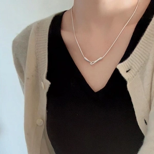 Detail of silver S925 snake chain necklace with unique overlapping tubular pendant on model