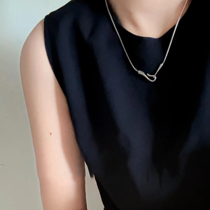 Detail view of the sleek silver snake chain with minimalist fishhook clasp design