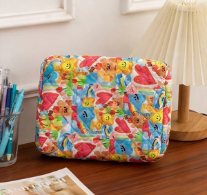 Detail of colorful quilted cotton toiletry bag with cartoon prints on wooden desk