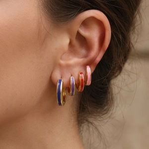 Model wearing 18K gold plated enamel hoop earrings in colorful drip oil finishes