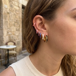 Close-up of 18K gold plated colorful enamel hoop earrings and cuff on model ear