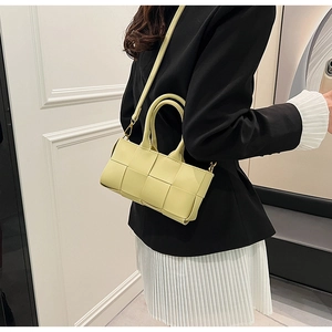 Elegante borsa a tracolla intrecciata gialla abbinata a un blazer nero di classe
