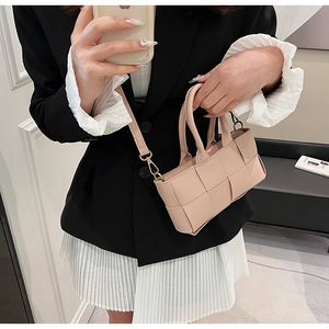 Dettaglio della mini borsa quadrata intrecciata rosa chiaro con doppia impugnatura