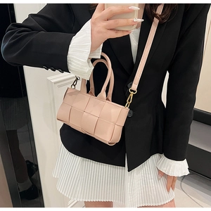 Dettaglio della mini borsa quadrata in pelle intrecciata rosa chiaro con tracolla e manico