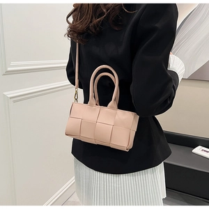Dettaglio borsa a mano intrecciata rosa indossata con blazer e gonna bianca