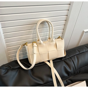 Dettaglio della borsa a mano intrecciata bianco crema con finiture in metallo oro