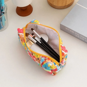Close-up of quilted floral makeup bag interior holding brushes and skincare bottles