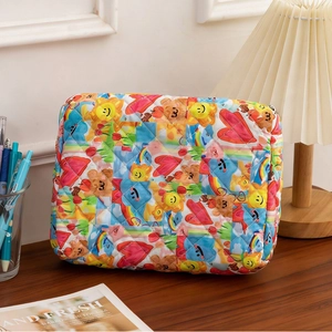 Quilted cotton makeup bag with colorful bear and rainbow prints on wooden desk