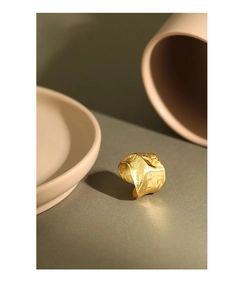 Detailed close-up of a minimalist gold irregular wrinkled textured open silver ring