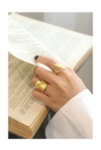 Close-up of irregular textured gold rings set worn on hand for a vintage aesthetic look