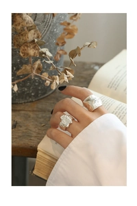 Detailed view of S925 sterling silver rings with irregular lava texture on hand
