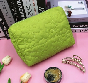 Detailed view of neon green quilted makeup bag with daisy floral stitching and zipper