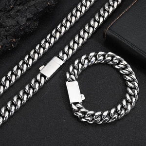 Détail macro du collier et bracelet chaîne cubaine en acier inoxydable sur pierre noire