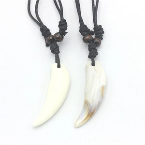 Close-up of faux wolf tooth pendants with acrylic shell texture and wooden beads