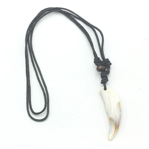 Detail of tribal style faux wolf tooth pendant with rustic wood beads and black cord