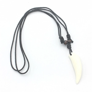 Close-up of faux wolf tooth pendant with black braided rope and wooden beads