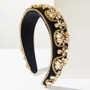 Close-up of luxury baroque headband featuring gold crystals and floral rhinestones on black velvet