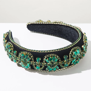 Detail of baroque headband with green crystals and gold trim on black velvet
