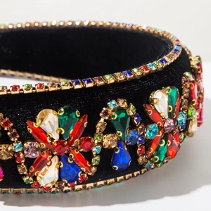 Macro shot of colorful rhinestones on vintage black velvet headband with floral patterns