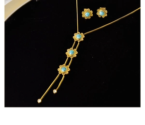 Nahaufnahme von goldenem Blumenschmuck-Set mit Türkissteinen und Zirkonia