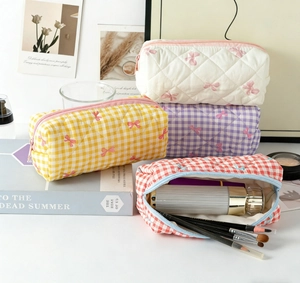 Close-up of quilted plaid cosmetic bags showing spacious interior and bow patterns