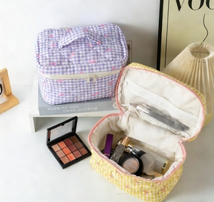 Detailed interior of quilted plaid cosmetic bag showing mesh pockets and large storage space
