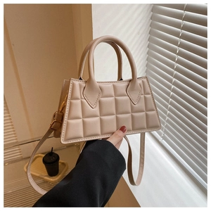 Détail du mini sac bandoulière matelassé beige avec poignée et texture en similicuir