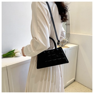Détail du sac à main noir en cuir PU matelassé avec poignée structurée et bandoulière